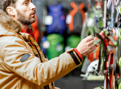 A man picking out ski gear at a ski rental shop