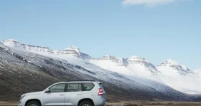 A ski transfer car in front of snowy peaks